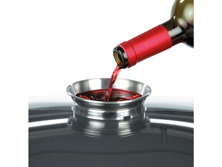 Roter Wein wird in einen Metallbehälter gegossen.