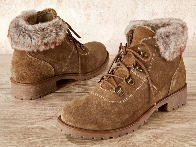 Zwei braune Wildlederstiefel mit Fellkragen.