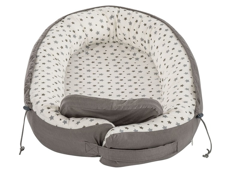 Ein graues Baby-Nestchen mit weißem Sternenmuster.