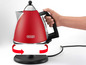 Ein roter Delonghi Wasserkocher mit drehbarer Basis.