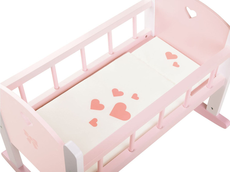 Ein rosa Holz-Wiegebett mit einer weißen Matratze und rosa Herzen.