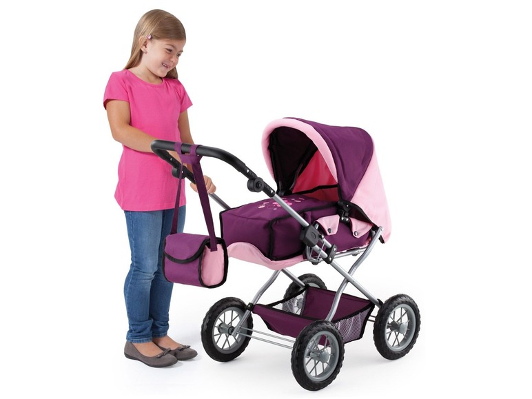 Ein Mädchen mit einem rosa T-Shirt schiebt einen rosa und lila Puppenwagen.