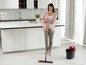 Eine Frau reinigt den Boden mit einem Vileda-Mop und -Eimer.