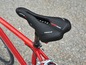 Ein schwarzer Sattel von Medicus Air auf einem roten Fahrrad.