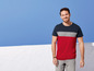 Mann in einem rot-grau-marineblauen T-Shirt mit Jeans