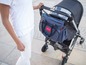 Eine Person schiebt einen Kinderwagen mit einer Oh My Baby! Wickeltasche.
