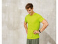 Mann in einem leuchtend grünen T-Shirt mit Fitness-Tracker.