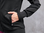 Eine schwarze Trainingsjacke mit einer Tasche.