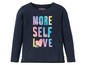 Ein dunkelblaues Langarmshirt mit dem Aufdruck 'More Self Love' in Regenbogenfarben.