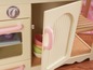 Eine Holzspielküche mit Backofen, Schrank und Schüsseln.