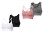 Vier nahtlose Sport-BHs in Weiß, Schwarz, Rosa und Grau.
