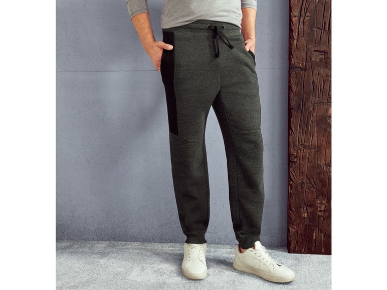Mann trägt dunkelgraue Jogginghose mit schwarzen Details.