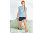 Ein Mädchen trägt einen blauen Schlafanzug mit Weltkarten-Print und Shorts.