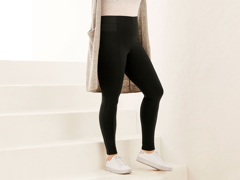 Schwarze Leggings mit hoher Taille und einem grauen Cardigan.