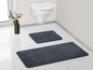 Zwei dunkelgraue Badezimmerteppiche in einem Badezimmer.