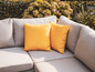 Eine graue Gartencouch mit gelben Kissen.