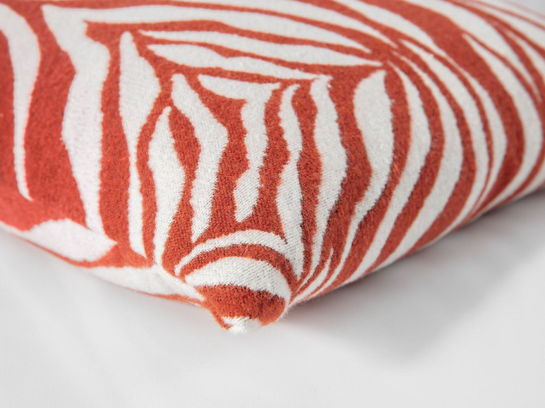 Ein Kissen mit einem Zebra-Muster in Rot und Weiß.