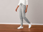 Ein Model trägt graue Jogginghosen und weiße Turnschuhe.