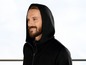 Mann in einem schwarzen Kapuzenpullover mit Reißverschluss.