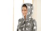 Eine Frau trägt einen grauen Fleece-Pyjama mit Sternen und Monden.