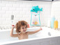 Ein Kind badet in einer Wanne mit Spielzeug und einem Delphin-förmigen Netz für Spielzeug.