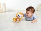 Ein Baby schaut sich ein Spielzeuglöwe auf Rädern an.
