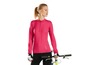 Eine Frau in einem rosa Fahrrad-Oberteil und schwarzen Radhosen mit einem Fahrrad.