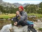 Ein Mann trinkt Kaffee aus einer Thermoskanne während einer Wanderung in den Bergen.