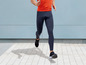Ein Mann, der in schwarzen Leggings und Laufschuhen läuft.
