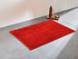 Eine rote Badezimmermatte auf dem Boden.