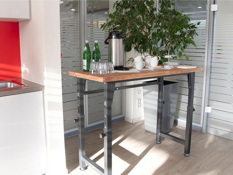 Ein Holztisch mit Glasflaschen und Tassen in einer Büro Küche.