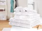Ein Stapel weißer Handtücher im Badezimmer.