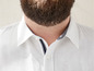 Ein weißes Hemd mit einem dunkelblauen Streifen am Kragen.