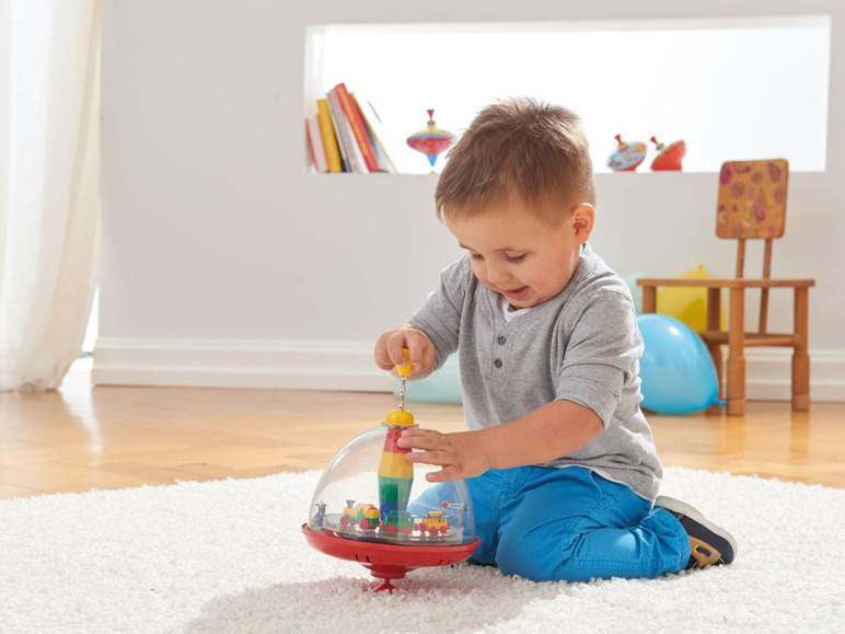 Ein Junge spielt mit einem Kreisel mit Zügen.