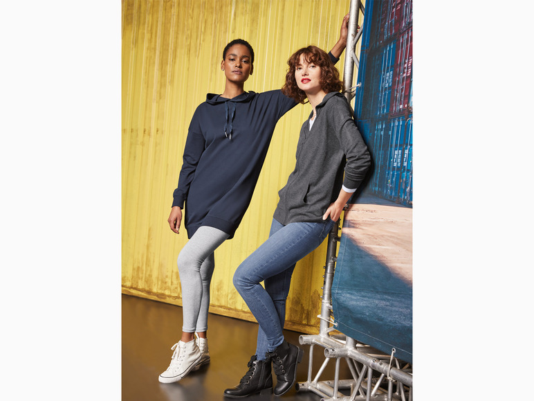 Zwei Frauen tragen Hoodies und Leggings, ein lässiger Look.