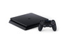 Eine schwarze PlayStation 4 Konsole mit Controller.