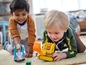 Zwei Jungen spielen mit einem LEGO-LKW und -Bagger.