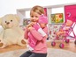 Ein Mädchen hält eine Puppe, im Hintergrund ein rosafarbener Kinderwagen.
