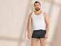 Mann in weißem Tanktop und gestreiften Boxershorts.