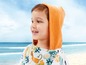 Ein Kind in einem orangefarbenen Bademantel mit Kapuze am Strand.