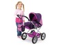 Ein Mädchen mit einem rosa Pullover und einem lila Puppenwagen.