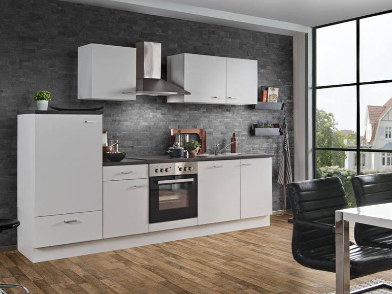 Eine moderne weiße Küche mit Backofen, Spüle und einer schwarzen Fliesenwand.