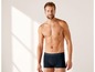 Mann in dunkelblauen Boxershorts.