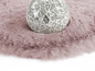 Ein rosa Plüschteppich mit einer dekorativen Glaskugel.