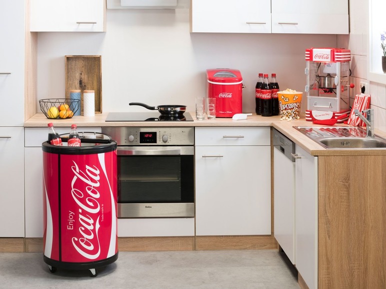Ein Coca-Cola-Kühlschrank in einer Küche mit einer Popcornmaschine.