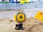 Eine gelbe GoPro-Kamera im Sand am Strand.