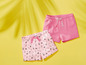 Zwei rosa Shorts für Mädchen, eine mit Eiscreme-Muster.