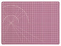 Eine rosa Schneidematte mit einem Winkelmesser und einem Raster.