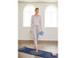 Frau in Yogakleidung mit Yogamatte und Blöcken.
