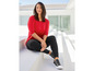 Eine Frau in einem roten Pullover und schwarzen Leggings.